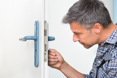 Carpenter Fixing Lock In Door With Screwdriver